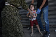 <p>An Iraqi paramedic calms a child, who suffered a shock following a suicide attack as they were escaping the Old City of Mosul, upon their arrival to the area of a field hospital on June 23, 2017. (Photo: Mohamed el-Shahed/AFP/Getty Images) </p>