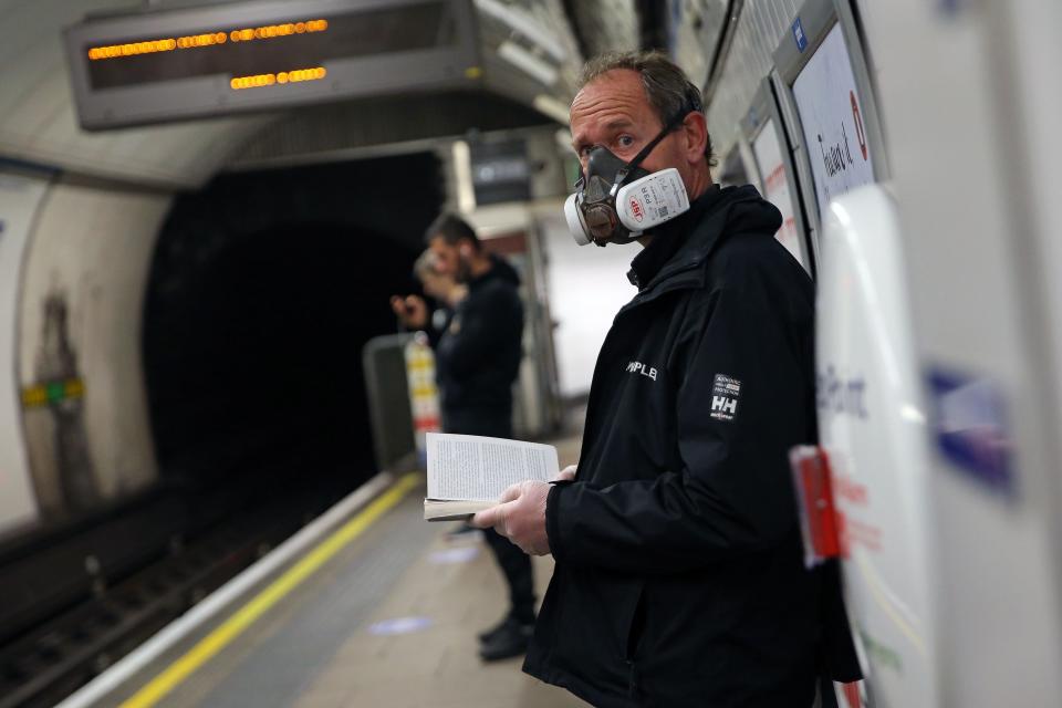 A commuter wearing PPE (personal protective equipment), including a face mask as a precautionary measure against COVID-19, travel waits on th eplatform at Oxford Circus to travel on a TfL (Transport for London) London underground Victoria Line train in central London on May 13, 2020, as people start to return to work after COVID-19 lockdown restrictions were eased. - Britain's economy shrank two percent in the first three months of the year, rocked by the fallout from the coronavirus pandemic, official data showed Wednesday, with analysts predicting even worse to come. Prime Minister Boris Johnson began this week to relax some of lockdown measures in order to help the economy, despite the rising death toll, but he has also stressed that great caution is needed. (Photo by ISABEL INFANTES / AFP) (Photo by ISABEL INFANTES/AFP via Getty Images)