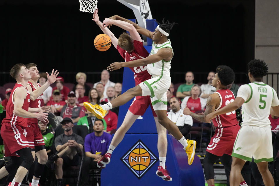 Wisconsin's Steven Crowl, center left, and North Texas' Jayden Martinez (24) battle for a rebound during the second half of an NCAA college basketball game in the semifinals of the NIT, Tuesday, March 28, 2023, in Las Vegas. (AP Photo/John Locher)