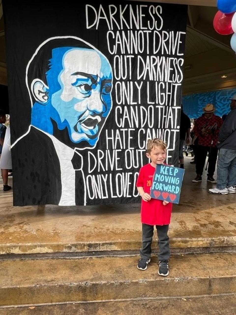 Jupiter Ewing, 5, holds his sign up on Martin Luther King Jr. Day at a celebration for the civil rights leader at Downtown City Park in Paso Robles on Jan. 17, 2022.