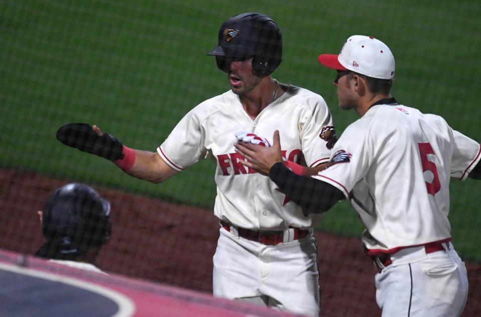 Fresno Grizzlies Parker Kelly, center, celebrates after scoring in the 9th inning against the Stockton Ports Tuesday, April 11, 2023 in Fresno.