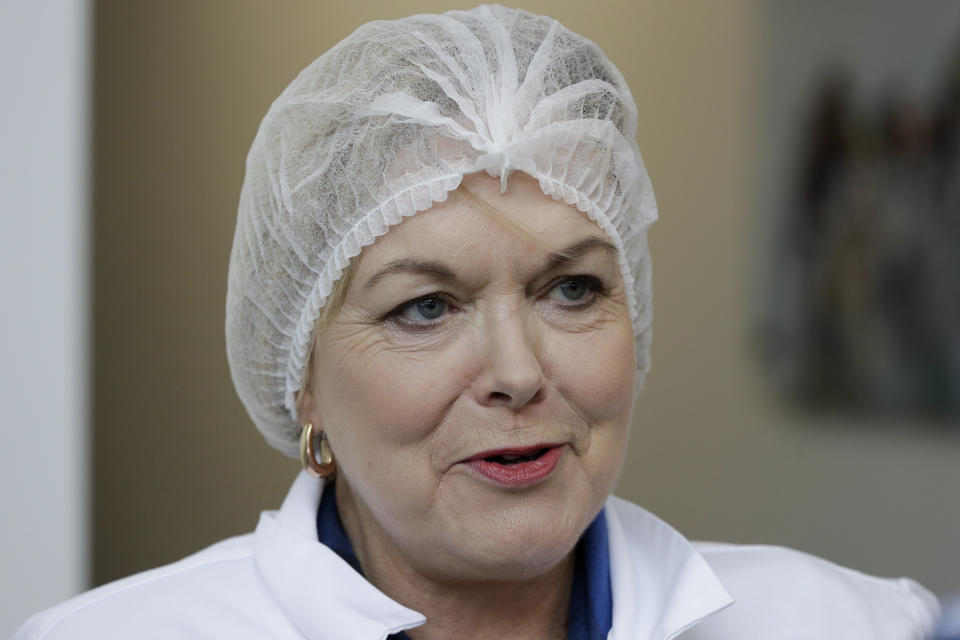 FILE - In this July 30, 2020, file photo, New Zealand opposition National Party leader Judith Collins, wearing a hairnet, waits to enter a salmon factory in Christchurch, New Zealand. New Zealand has suffered a steep economic downturn due to the virus and is borrowing billions of dollars to try and stem job losses and rebuild. National is promising to increase infrastructure spending. (AP Photo/Mark Baker, File)