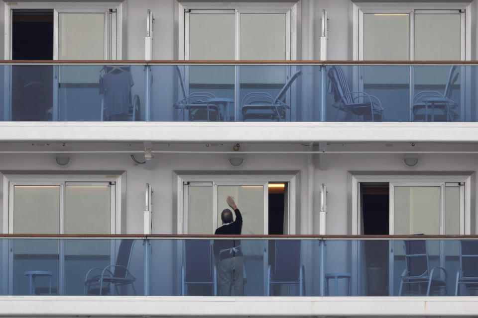 A passenger cleans the window of his cabin on the quarantined Diamond Princess cruise ship Saturday, Feb. 15, 2020, in Yokohama, near Tokyo. A viral outbreak that began in China has infected more than 67,000 people globally. The World Health Organization has named the illness COVID-19, referring to its origin late last year and the coronavirus that causes it. (AP Photo/Jae C. Hong)