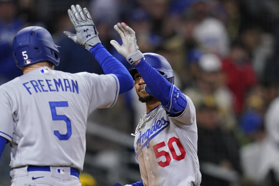 Los Angeles Dodgers' Mookie Betts (50) is greeted by Freddie Freeman after hitting a home run during the fifth inning of the team's baseball game against the San Diego Padres, Friday, April 22, 2022, in San Diego. (AP Photo/Gregory Bull)