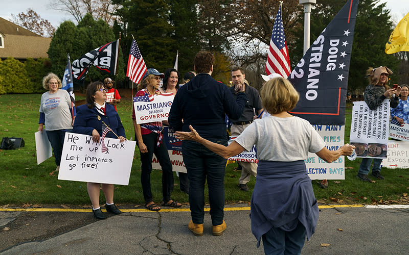 Supporters of Pennsylvania Republican candidate for governor Doug Mastriano speak to a supporter of Democratic candidate for governor Josh Shapiro