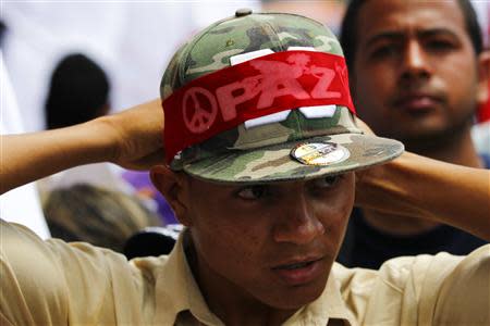 A supporter of Venezuelan President Nicolas Maduro attends a march in support of the government and to call for peace after the recent deadly violence following street protests, in Caracas February 15, 2014. REUTERS/Carlos Garcia Rawlins