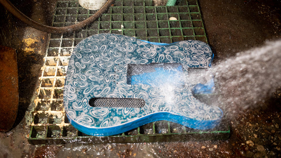 The body of a James Trussart's guitar gets washed after being screen printed and sprayed with the fixer at Trussart's workshop in East Los Angeles.