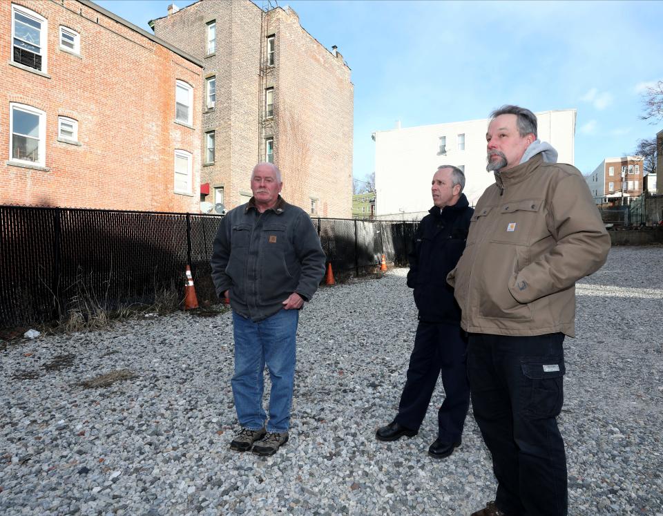 Retired Yonkers Fire Captain Ed Miley, Retired Assistant Chief Kyran Dunn and Retired Commissioner George Kielb are pictured at about the spot where the fatal Oak Street fire began on March 14, 2003. By the time the flames were extinguished, about 14 buildings would be damaged, 6 buildings collapsed, about 200 people would be homeless and Pedro and Julia Elena Velez would be dead, found in each other's arms in the alley between the two brick buildings over Miley's right shoulder. The farthest traffic cone behind the firefighters is about where Brian and Peter Velez and Vanessa Lugo began their run through a 3-foot-wide, 50-foot high tunnel of flame, one of the men clutching Peter and Vanessa's 8-month-old daughter, Vaniya.