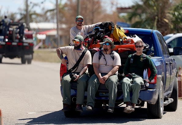 Search and Rescue personnel ride in be back of a truck on October 2, 2022, in Pine Island, Florida. Residents are being encouraged to leave because the only road onto the island is impassable and electricity and water remain knocked out after Hurricane Ian passed through the area.