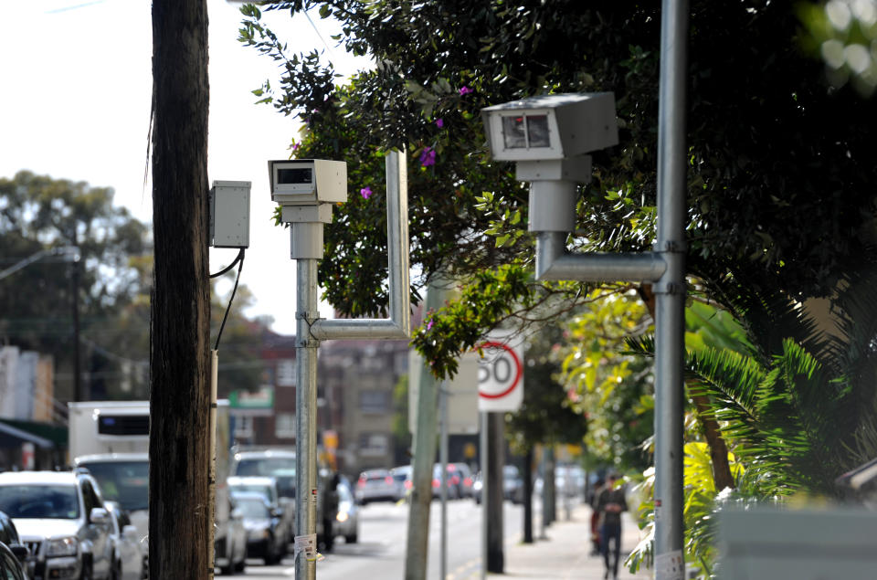 Picture of speed cameras on a Sydney road, with traffic passing by. 