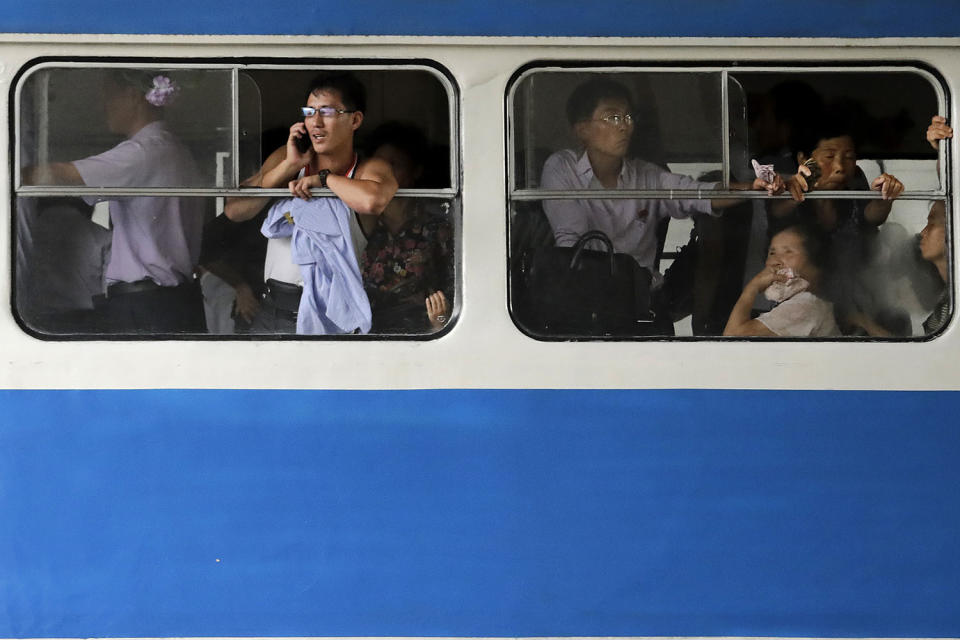 <p>A man talks on his mobile phone as he and other commuters ride in an electric trolley downtown Pyongyang at the end of a workday on July 28, 2017, in North Korea. (Photo: Wong Maye-E/AP) </p>