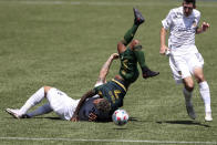 Portland Timbers midfielder Andy Polo (7) flips over LA Galaxy defender Derrick Williams (3) as LA Galaxy midfielder Sacha Kljestan (16) runs alongside them during the first half of an MLS soccer match, Saturday, May 22, 2021, in Portland, Ore. Williams received a red card for the foul. (AP Photo/Amanda Loman)