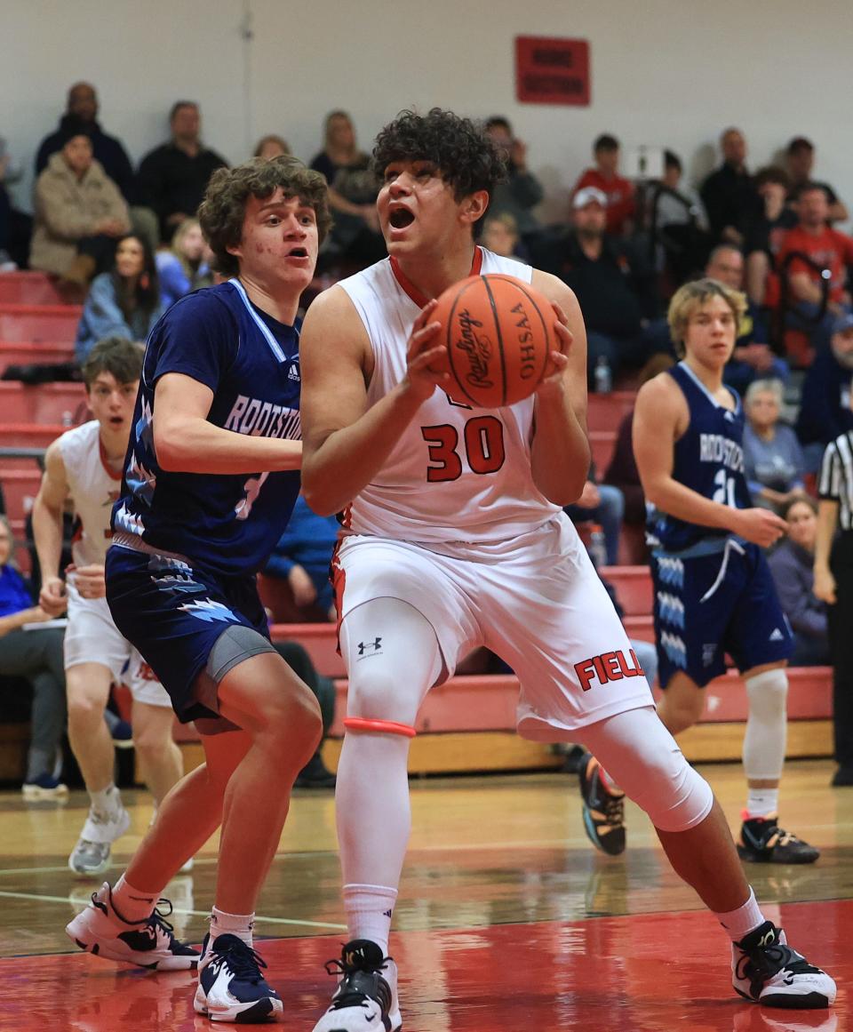 Field senior Brayden Cadwell powers his way under the basket to score during Tuesday night’s game against the Rootstown Rovers at Field High School. The Falcons defeated Rootstown 61-50.