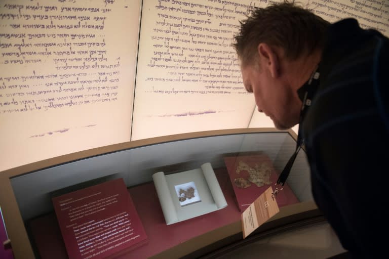 Visitors look at what could be fragments of the Dead Sea scrolls, though many scholars question the relics' authenticity