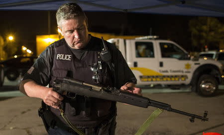 A Cook County Sheriff police officer holds an assault rifle recovered in an alley in the Austin neighborhood in Chicago, Illinois, United States, September 9, 2015. Picture taken September 9, 2015. REUTERS/Jim Young