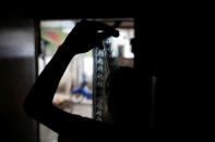 Kamaluddin checks a 35mm film strip at his workshop in Tangerang, Indonesia, March 11, 2017. REUTERS/Beawiharta