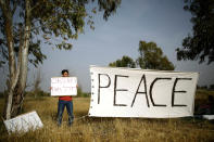 <p>An Israeli peace activist holds a sign in front of the Israel-Gaza border, as Palestinians protest on the Gaza side of the border near Kibbutz Nahal Oz, Israel, April 5, 2018. (Photo: Amir Cohen/Reuters) </p>