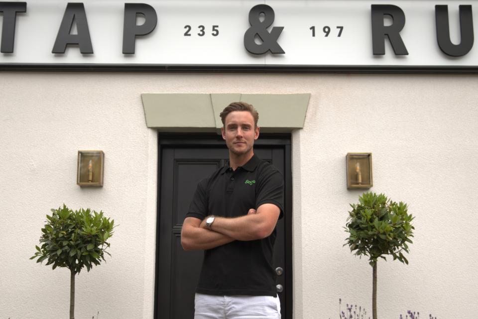 Former cricketer Stuart Broad stands outside the Tap & Run pub with his arms folded