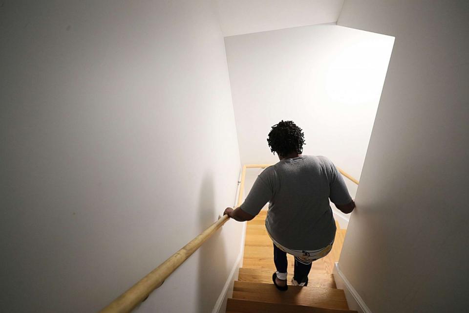 PHOTO: Tamika Samson, suffering from long covid, walks down the steps leading from her apartment, in Worcester, Mass., Aug. 23, 2023. (Boston Globe via Getty Images)