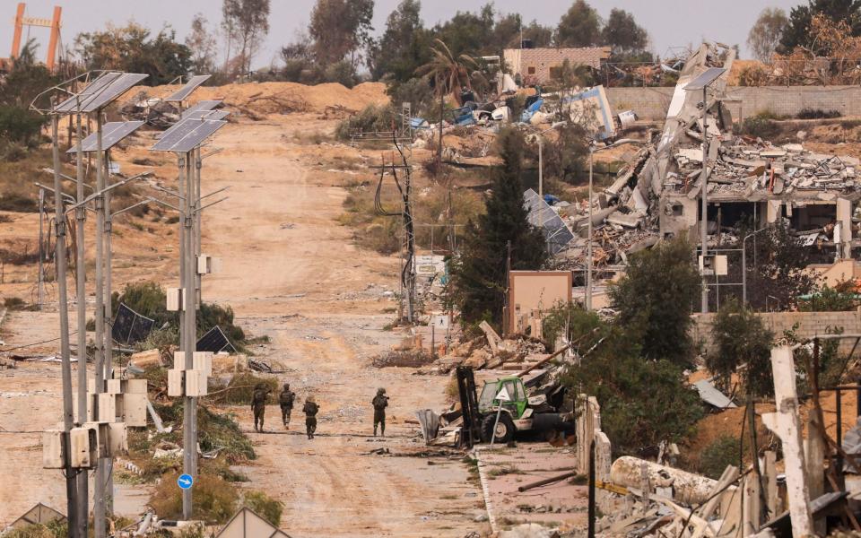 Israeli soldiers patrol in Gaza City's Zeitoun district on November 25, 2023, on the second day of a truce between Israel and Hamas.