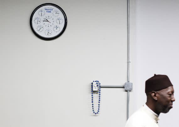 Imam Masud Tariq-Towe stands beneath a prayer clock in New York. (Lucas Jackson/Reuters)