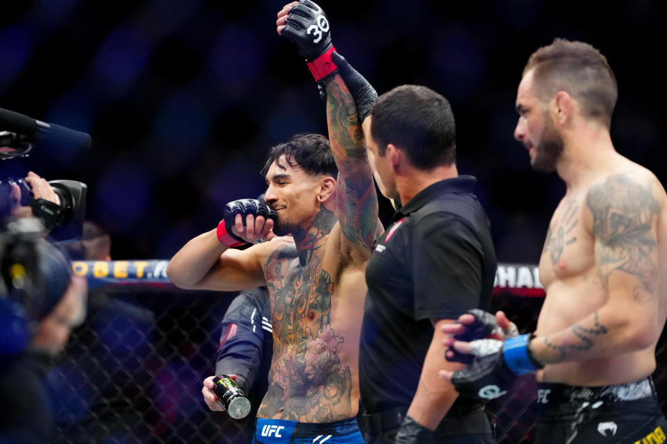 Dec 16, 2023; Las Vegas, Nevada, USA; Andre Fili (red gloves) reacts after defeating Lucas Almeida (blue gloves) during UFC 296 at T-Mobile Arena. Mandatory Credit: Stephen R. Sylvanie-USA TODAY Sports