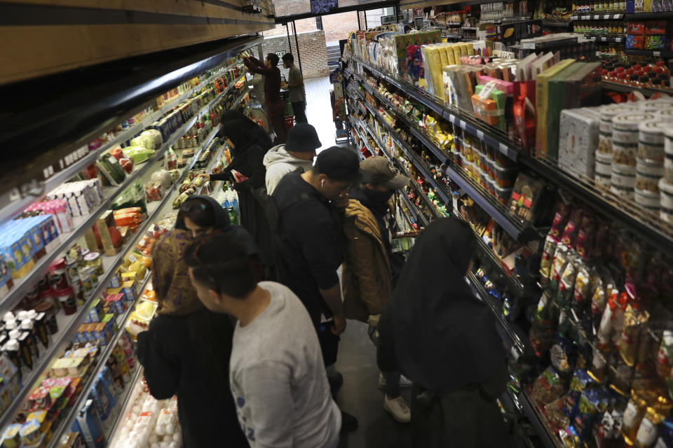 People shop at a grocery in Bamland shopping mall, in Western Tehran, Iran, Sunday, March 15, 2020. Many people in Tehran shrugged off warnings over the new coronavirus as authorities complained that most people in the capital are not treating the crisis seriously enough. (AP Photo/Vahid Salemi)