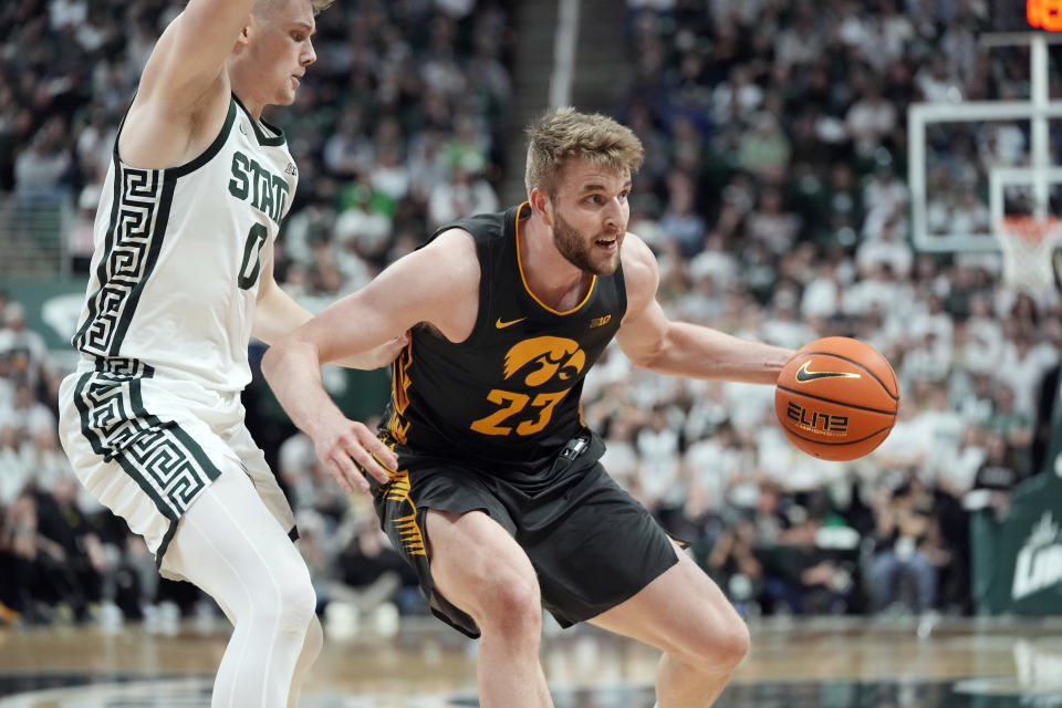 Iowa forward Ben Krikke (23) is defended by Michigan State forward Jaxon Kohler (0) during the first half of an NCAA college basketball game, Tuesday, Feb. 20, 2024, in East Lansing, Mich. (AP Photo/Carlos Osorio)