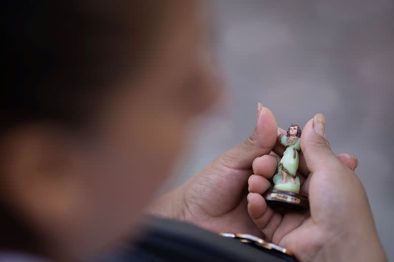 An Ecuadorean migrant holds a figure of a Christ child she carried with her on her journey through Mexico