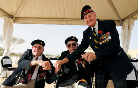 British World War Two veterans Alex Munro, 96, Joe Peel, 98, and Bill Blackburn,98, hold hands after a ceremony for the anniversary of the Battle of El Alamein, at El Alamein war cemetery in Egypt, October 20, 2018. REUTERS/Amr Abdallah Dalsh