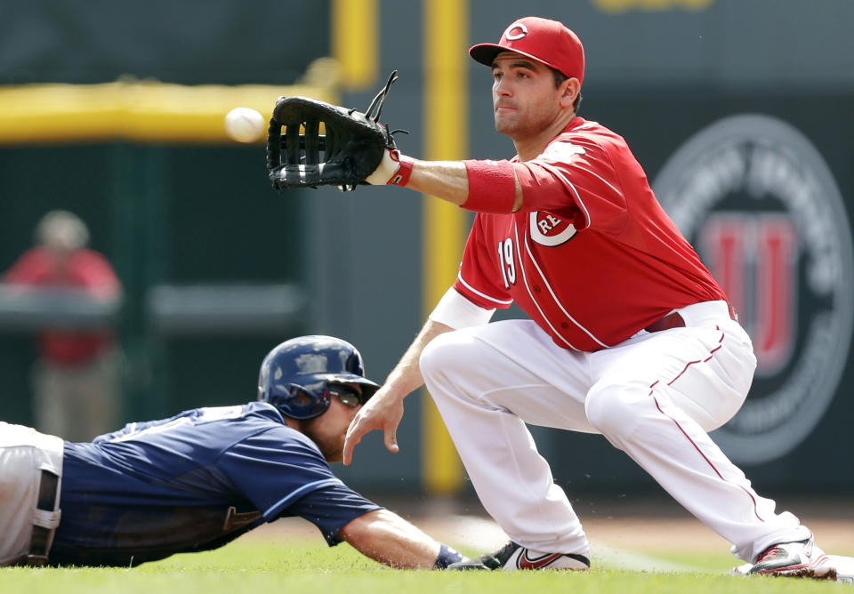 Tampa Bay Rays' Ben Zobrist dives safely back to first as Cincinnati Reds first baseman Joey Votto, right, catches a pickoff throw in the first inning of a baseball game, Saturday, April 12, 2014, in Cincinnati. (AP Photo/Al Behrman)