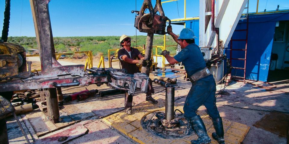Petroleum Workers Moving a Drill