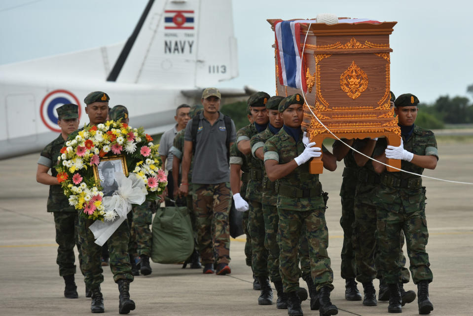 An honour guard carries the coffin of Saman Kunan, 38, a former member of Thailand’s elite navy SEAL unit who died working to save 12 boys and their soccer coach trapped inside a flooded cave, at an airport in Rayong province, Thailand, July 6, 2018. REUTERS/Panumas Sanguanwong