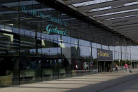 FILE - In this Wednesday, July 22, 2020 file photo, passengers walk into the Departures entrance at the North Terminal of Gatwick Airport near Crawley, just south of London. With all British schools now closed for the summer, airports and airlines are looking a tad more normal this Saturday, July 24, 2021 though the number of families heading off for warmer climes remains way down on the levels seen before the coronavirus pandemic struck. (AP Photo/Matt Dunham, File)