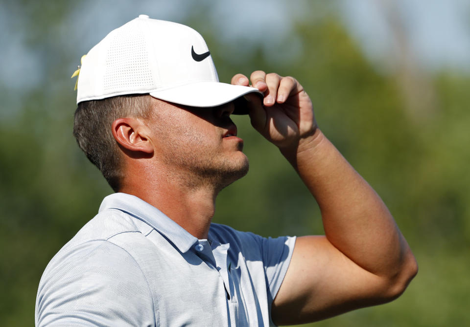 Brooks Koepka puts his hat on as he walk off the 14th tee during the third round of the PGA Championship golf tournament at Bellerive Country Club, Saturday, Aug. 11, 2018, in St. Louis. (AP Photo/Jeff Roberson)