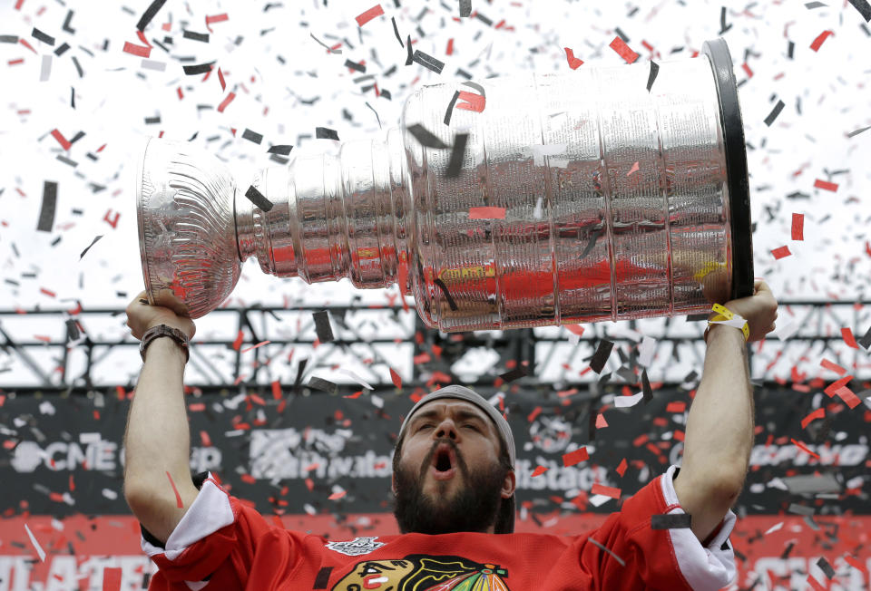 FILE - Chicago Blackhawks defenseman Brent Seabrook celebrates as he holds up the Stanley Cup Trophy during a rally at Soldier Field for the NHL Stanley Cup hockey champions, in Chicago, in this Thursday, June 18, 2015, file photo. Longtime Chicago Blackhawks defenseman and three-time Stanley Cup winner Brent Seabrook announced Friday, March 5, 2021, he’s unable to continue playing hockey because of injury. (AP Photo/Nam Y. Huh, File)