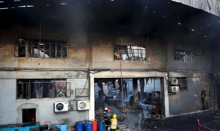 Firemen and rescuers look for the victims trapped in a fire at a factory in Valenzuela, Metro Manila in the Philippines May 13, 2015. REUTERS/Ezra Acayan