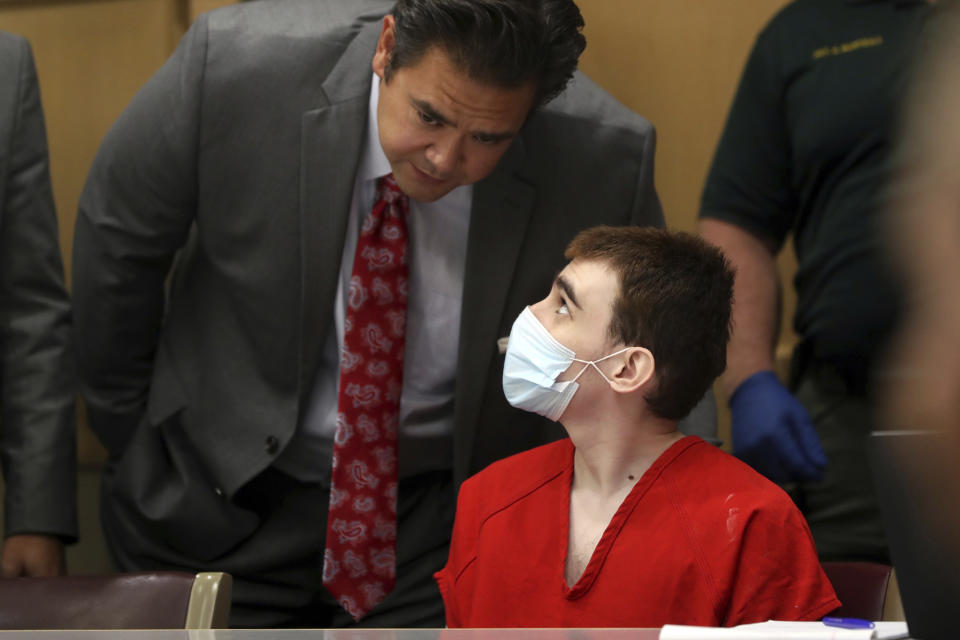 Defense attorney David Wheeler speaks with his client, Parkland school shooter Nikolas Cruz, during a pre-trial hearing at the Broward County Courthouse in Fort Lauderdale, Fla., Wednesday, July 14, 2021, on four criminal counts stemming from his alleged attack on a Broward jail guard in November 2018. Cruz is accused of punching Sgt. Ray Beltran, wrestling him to the ground and taking his stun gun. (Amy Beth Bennett/South Florida Sun-Sentinel via AP, Pool)