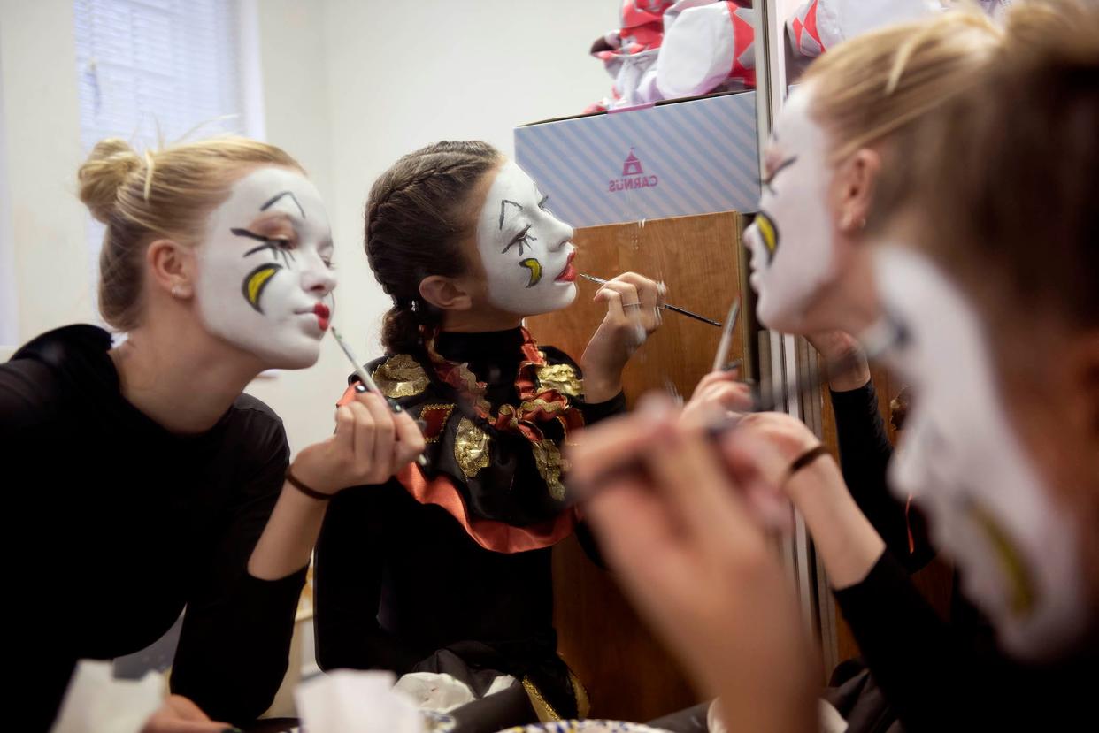 Preparing for their roles as little jesters Elisabeth Dziedzic, 18, from left, Rell Clemente, 12, and Bethanny Bautz, 13, apply makeup before the 2024 Boar's Head and Yule Log Festival on Saturday.