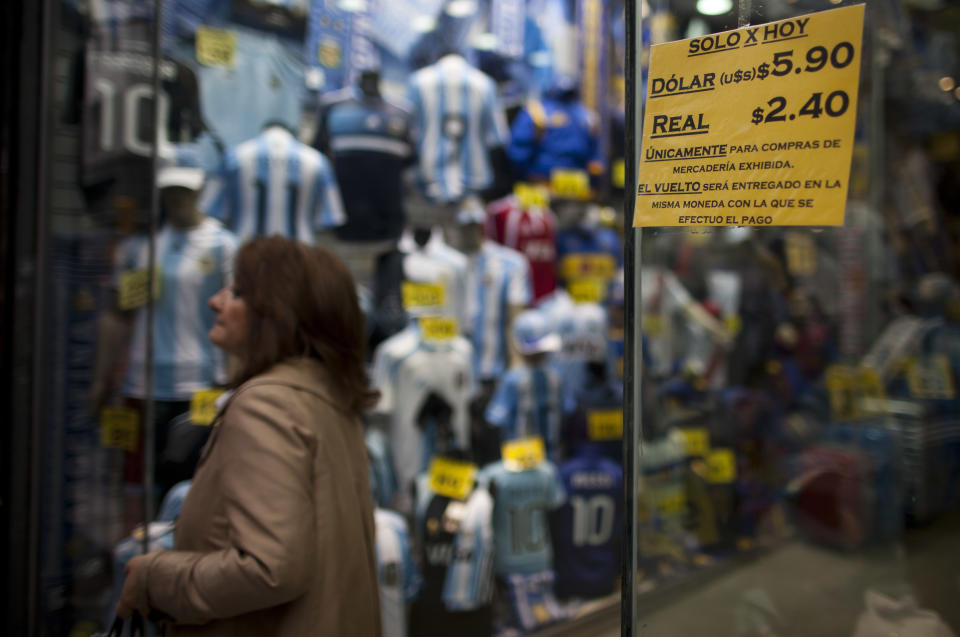 A shop window displays a sign that reads in Spanish: "Only for today, Dollar 5.90, Real 2.40," in Buenos Aires, Argentina, Monday, May 28, 2012. Argentina is making it harder for people to buy U.S. dollars to pay for travel abroad. A new rule published Monday says anyone wanting to buy dollars for travel must first prove their money was obtained legally, and provide the tax agency with trip details including why, when and where they are traveling. President Cristina Fernandez is cracking down to keep hard currency from flowing out of Argentina, which needs the dollars to maintain its central bank reserves and pay debts. (AP Photo/Natacha Pisarenko)