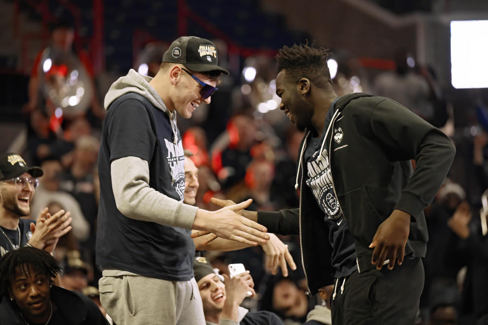 UConn's Donovan Clingan slaps hands with teammate Adama Sanogo during a rally at Gampel Pavilion in honor of the team's national championship, Tuesday, April 4, 2023, in Storrs, Conn. (AP Photo/Jessica Hill)
