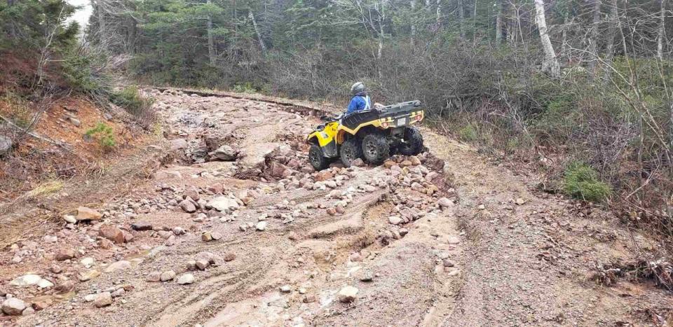 An all-terrain vehicle driving up a washed out section of the road to Mary Ann Falls.