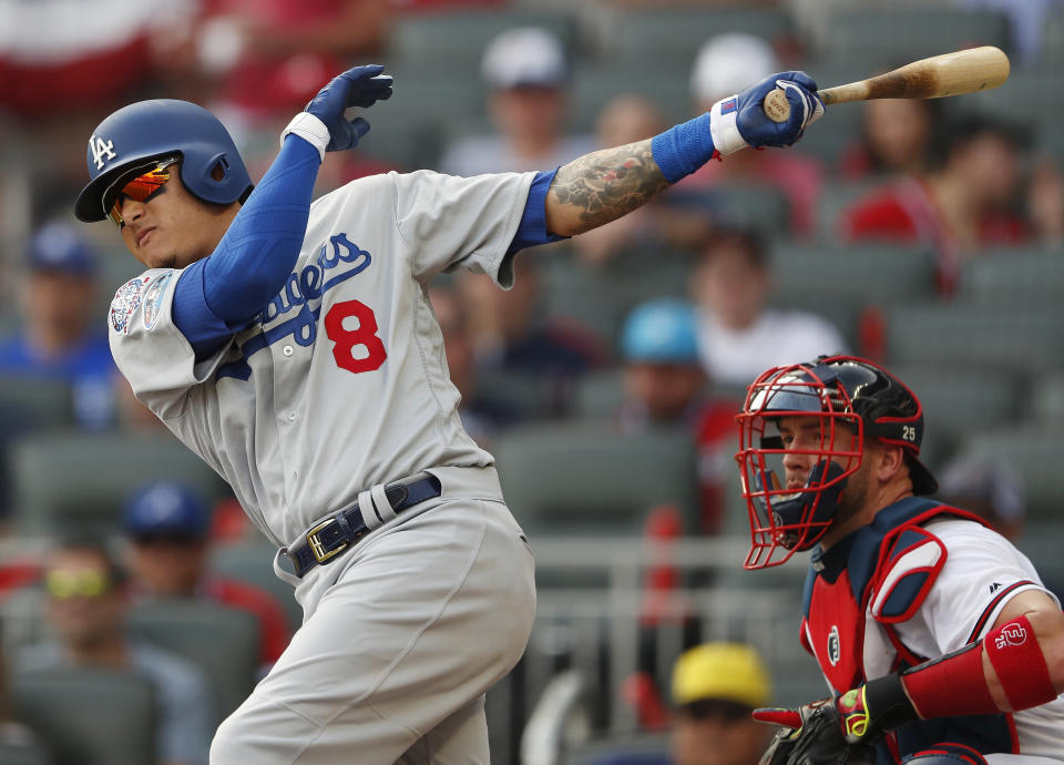 Los Angeles Dodgers shortstop Manny Machado (8) hits an RBI single against the Atlanta Bravesduring the first inning in Game 4 of baseball's National League Division Series, Monday, Oct. 8, 2018, in Atlanta. Los Angeles Dodgers' Max Muncy scored on the play. (AP Photo/John Bazemore)