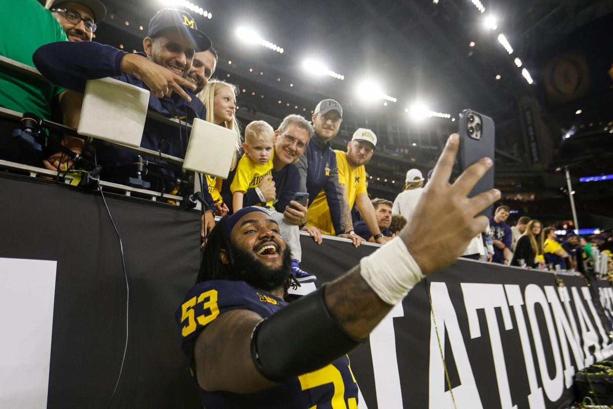 Michigan offensive lineman Trente Jones takes a selfie with fans to celebrate the 34-13 win over Washington to win the national championship game at NRG Stadium in Houston on Monday, Jan. 8, 2024.