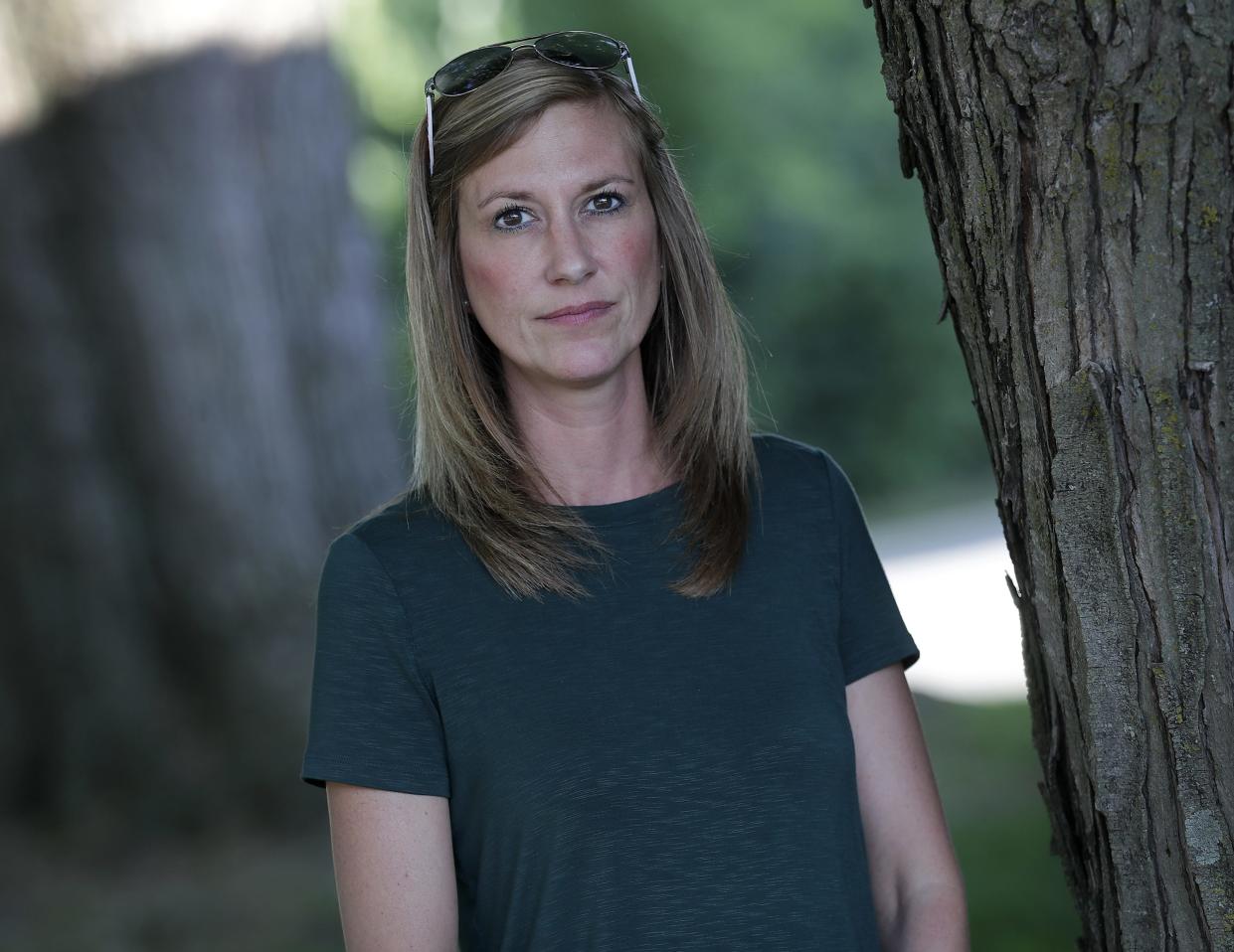 Amy Stephany stands in her yard in Menasha, across the street from Bucklin's Tree Service in Fox Crossing. Stephany says noise from Bucklin's wakes her from a dead sleep and disturbs the peace of the neighborhood.