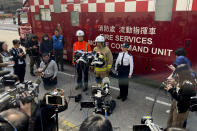 A firefighter briefs journalists on a fire that broke out at a construction site in Hong Kong, Friday, March 3, 2023. Hong Kong firefighters battled a blaze Friday that broke out overnight at a construction site in a popular shopping district and forced around people in nearby buildings to evacuate. (AP Photo)