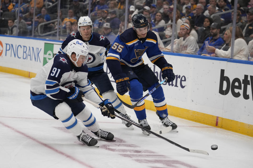 St. Louis Blues' Colton Parayko (55) chases after a loose puck along with Winnipeg Jets' Cole Perfetti (91) and Vladislav Namestnikov (7) during the third period of an NHL hockey game Tuesday, Nov. 7, 2023, in St. Louis. (AP Photo/Jeff Roberson)