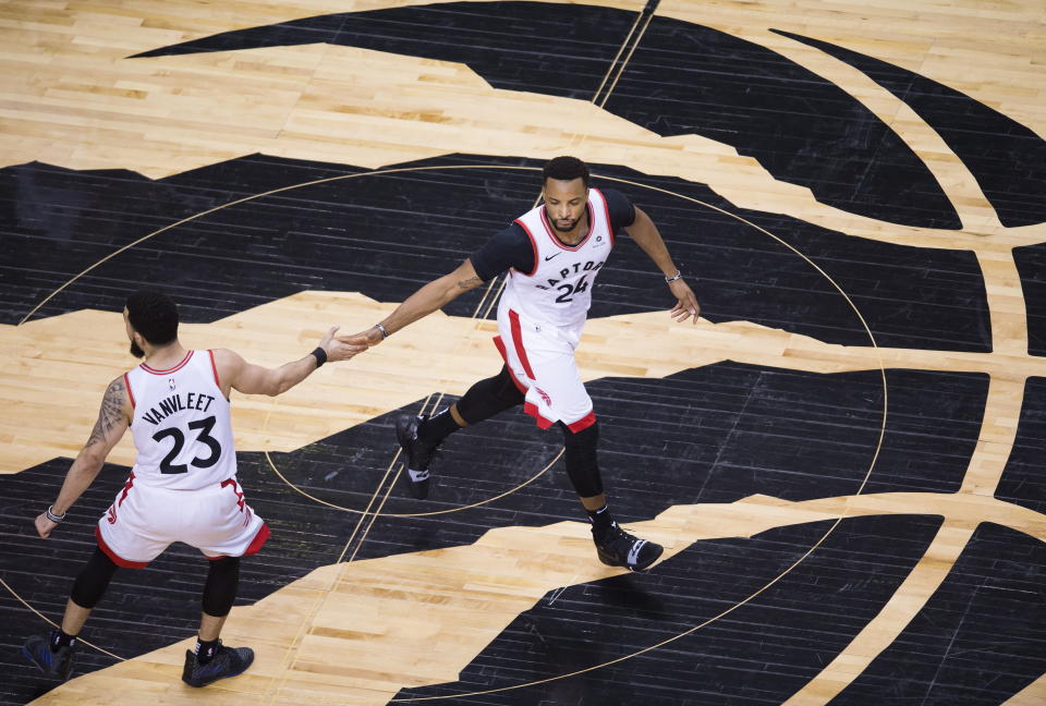 Toronto Raptors forward Norman Powell (24) celebrates his basket with Fred VanVleet (23) during the second half of Game 4 of the team's NBA basketball playoffs Eastern Conference finals against the Milwaukee Buck, Tuesday, May 21, 2019, in Toronto. (Nathan Denette/The Canadian Press via AP)