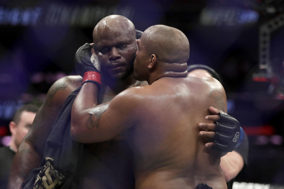 Daniel Cormier, right, gives a kiss to Derrick Lewis after Cormier won their heavyweight mixed martial arts bout by submission in the second round at UFC 230, early Sunday, Nov. 4, 2018, at Madison Square Garden in New York. (AP Photo/Julio Cortez)