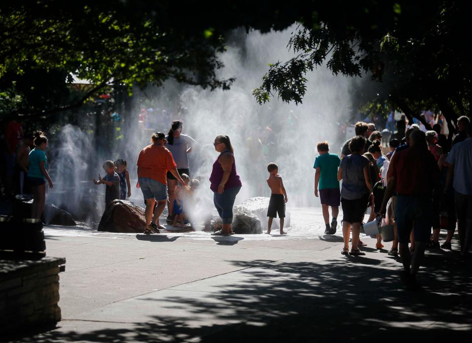 Fairgoers keep cool in the fountain at Pella Plaza during the Iowa State Fair in 2021.